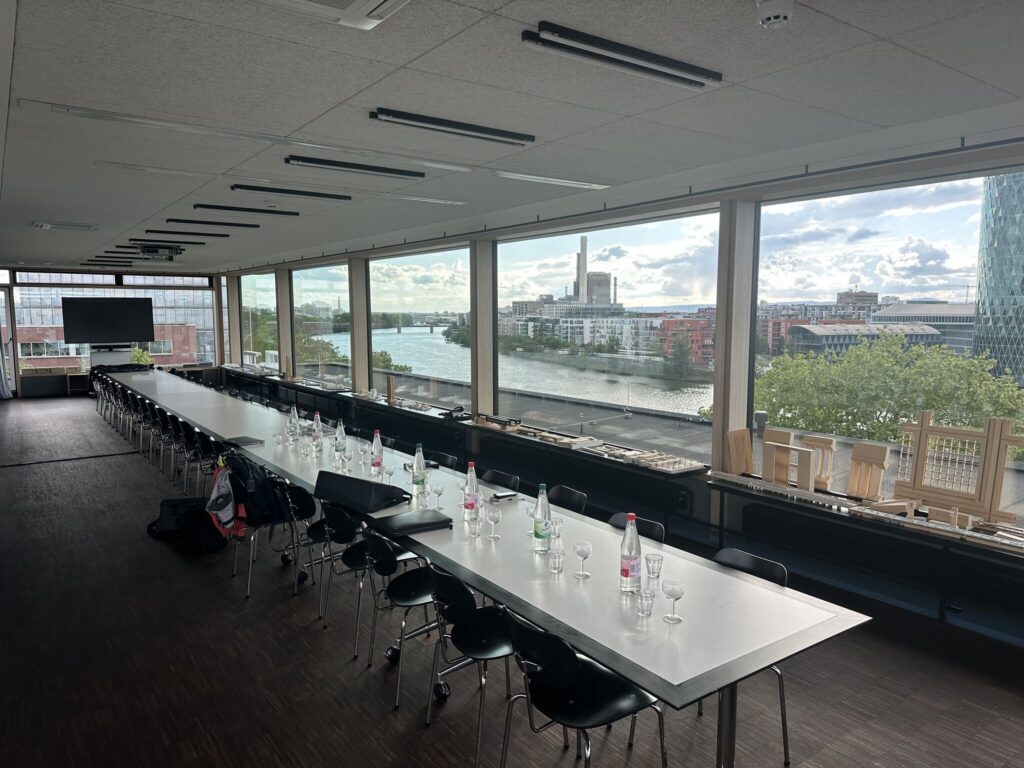 Frankfurts Skyline im Rücken, eine vollgepackte Agenda auf dem Tisch.